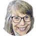 A woman with glasses smiling for the camera.