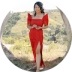 A woman in red dress standing on top of a hill.