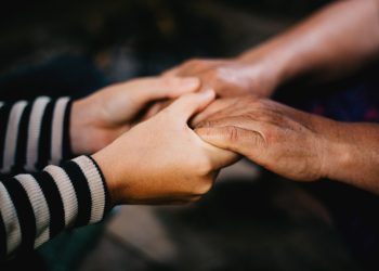Two people holding hands in a circle.